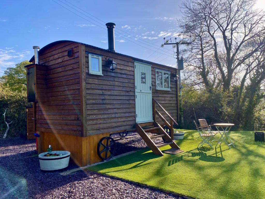 a tiny house with a staircase and a table at Shepherds Hut, Conwy Valley in Conwy