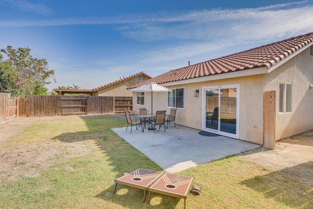 un cortile con tavolo, sedie e una casa di Bakersfield Home with Pool Table, Cornhole and More! a Bakersfield