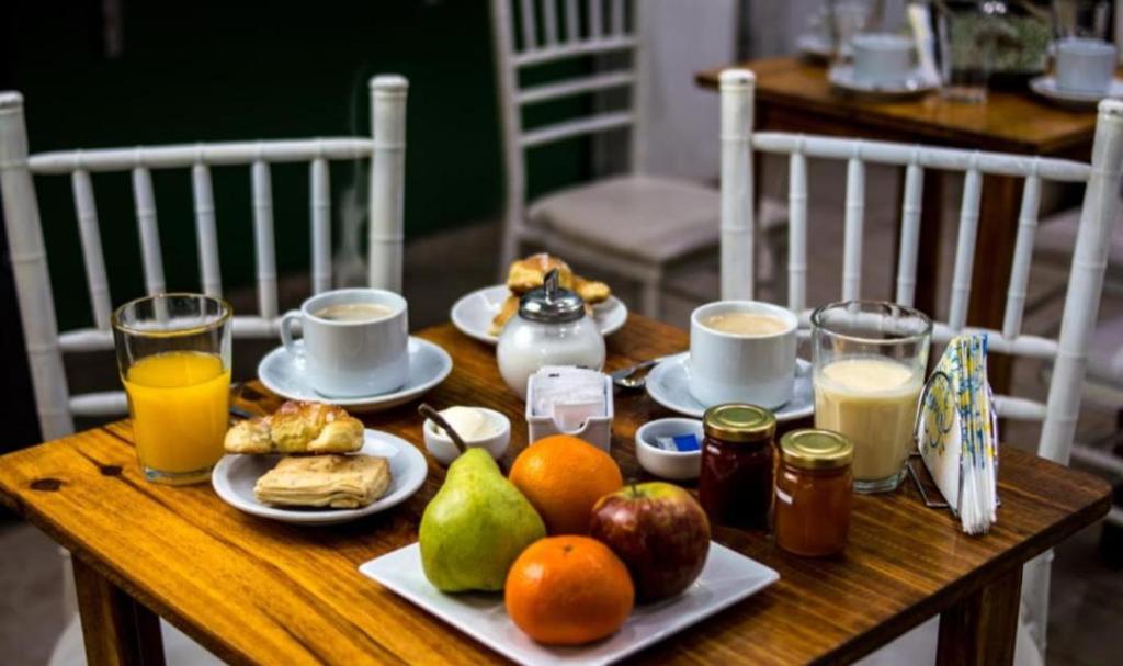 Hotel Interlagos في سان خوان: طاولة خشبية مليئة بأطباق الطعام والفواكه