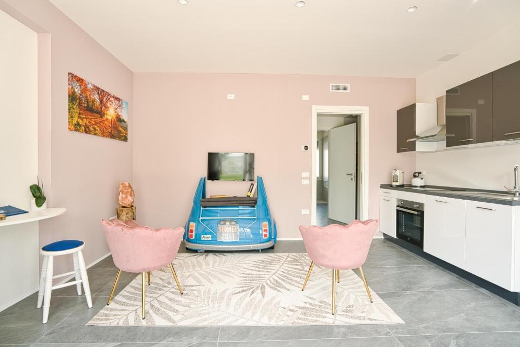 une cuisine avec deux chaises roses et un appareil bleu dans l'établissement Residence Diamante, à Villorba
