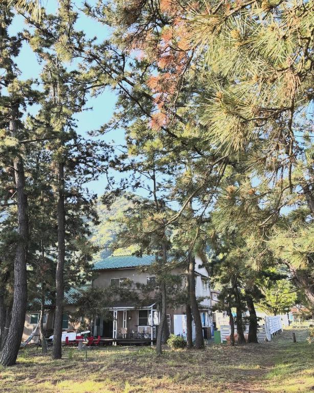 a house with trees in front of it at Kanzaki Beach House in Kanzaki