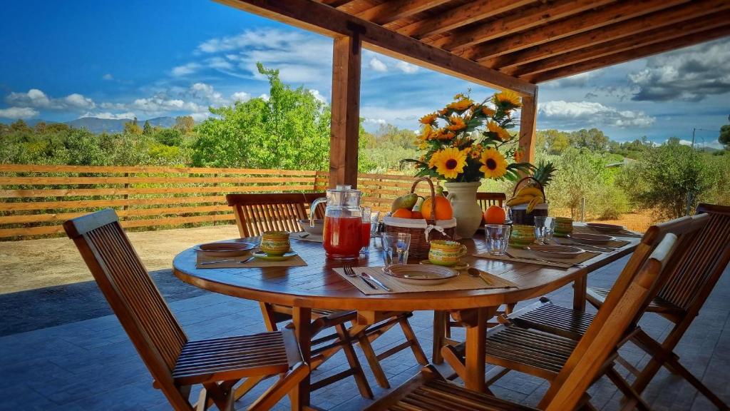 a wooden table with flowers and drinks on a patio at Villa Ginevra in Balestrate