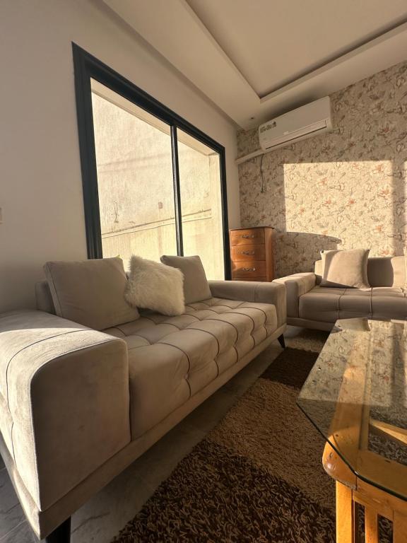 a living room with a couch and a large window at Coquette villa avec piscine in Tunis