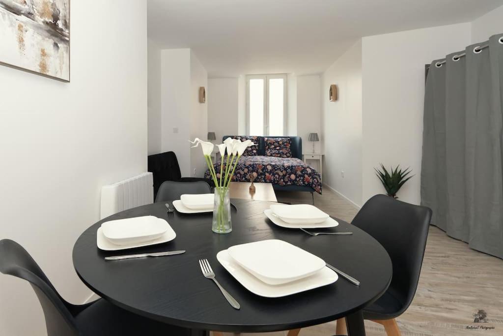 une salle à manger avec une table et des chaises noires dans l'établissement La résidence Jeanne d'Arc 1 , Troyes - France, à Troyes