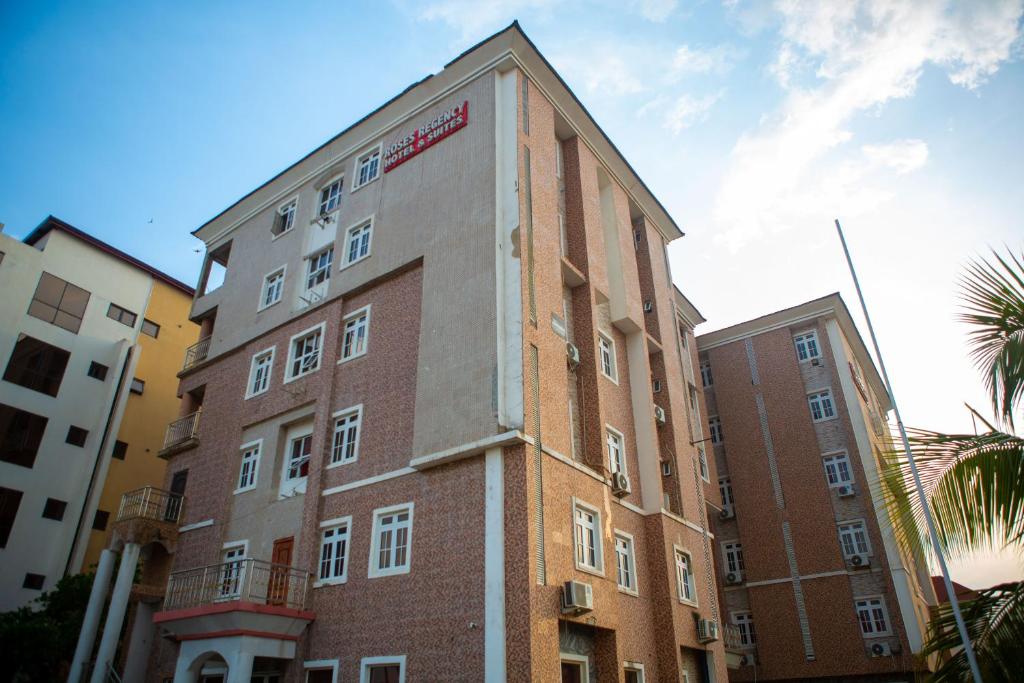 een hoog bakstenen gebouw met een bord aan de zijkant bij ROSES REGENCY HOTEL AND SUITES in Abuja