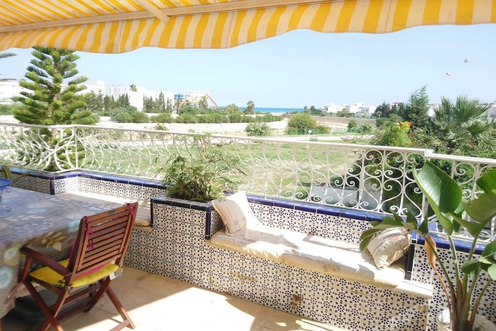 een balkon met een bank en een tafel en uitzicht bij Maison pied dans l'eau à résidence Jinène Hammamet in Hammamet