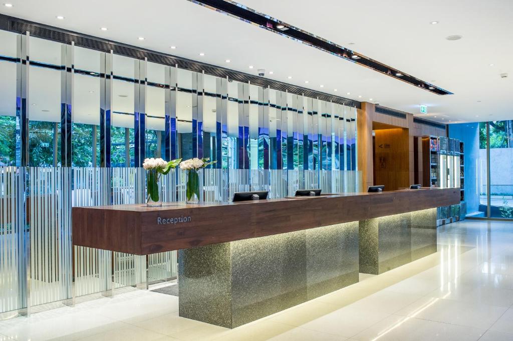 A long reception desk in a bright, contemporary hotel lobby.