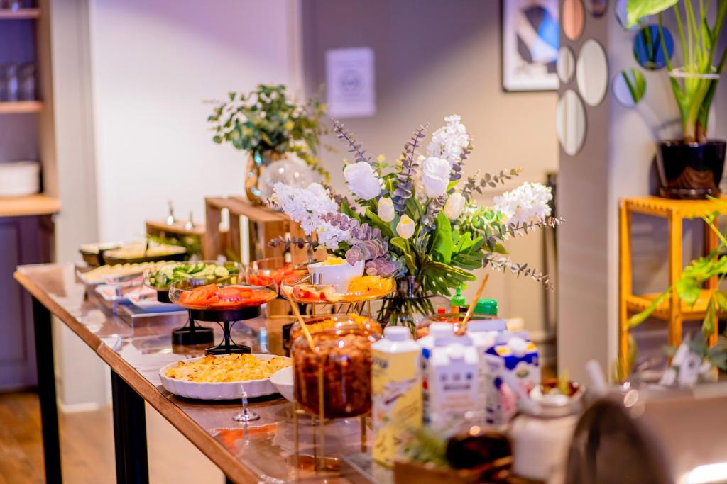 ストックホルムにあるHotel Expo Stockholmの花と食べ物が並ぶテーブル