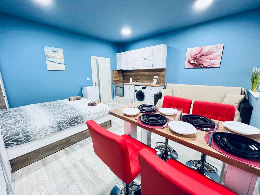 une pièce avec une table à manger et des chaises rouges dans l'établissement NJ Deluxe rooms, à Varna