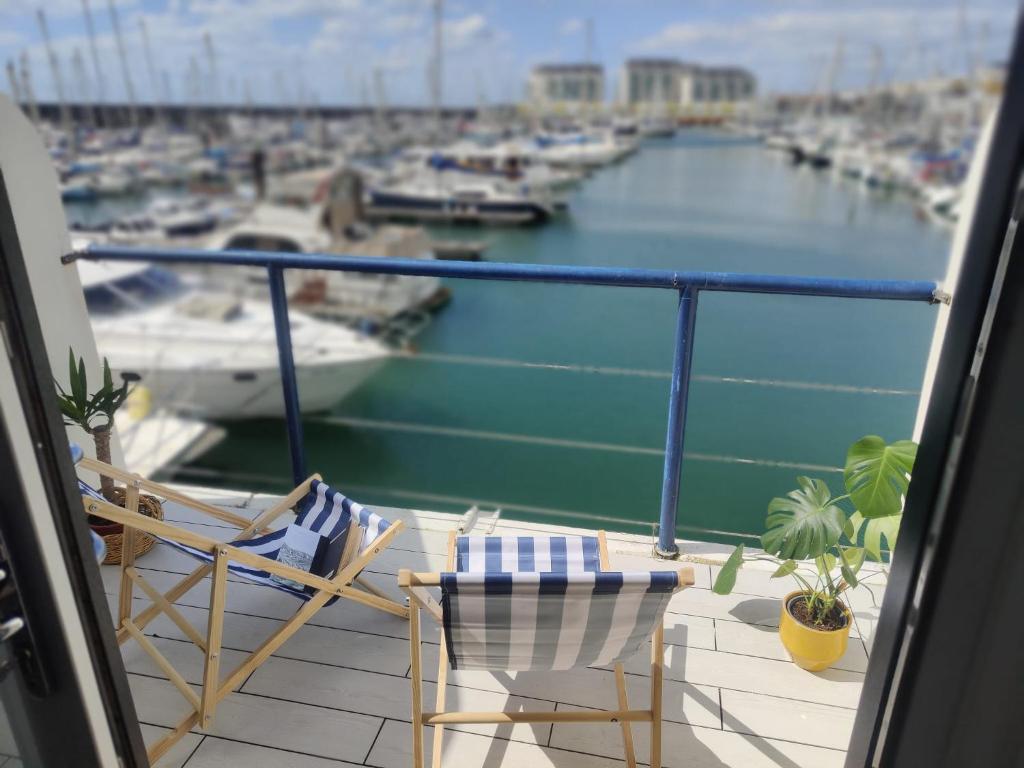 einen Balkon mit 2 Stühlen und Blick auf den Yachthafen in der Unterkunft Tiny float home Brighton in Brighton & Hove