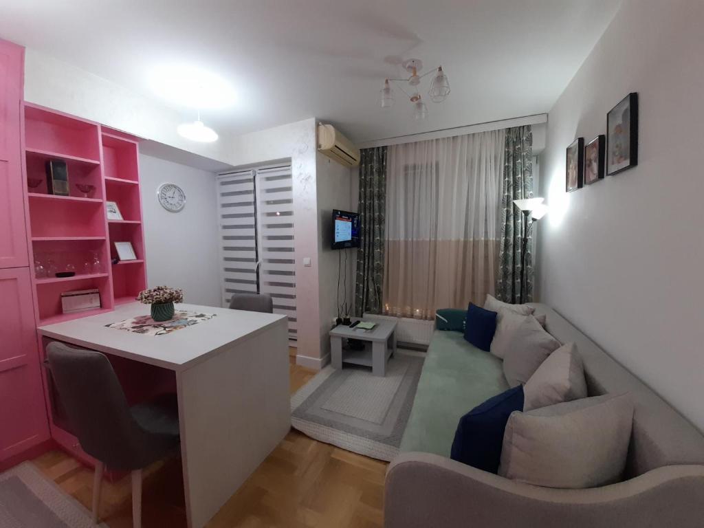 uma pequena sala de estar com um sofá e uma mesa em Apartman Talija em Kragujevac