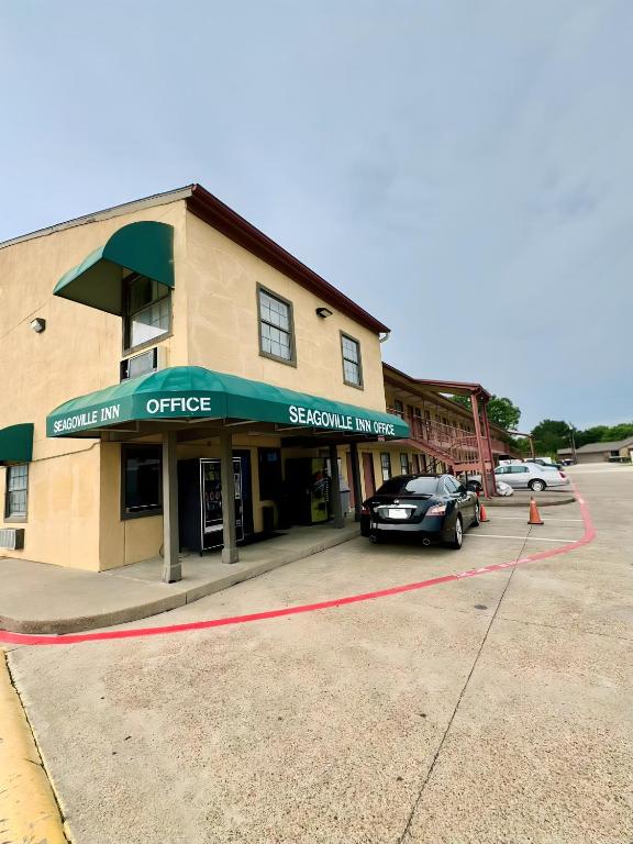 a building with a car parked in a parking lot at Seagoville Inn in Seagoville
