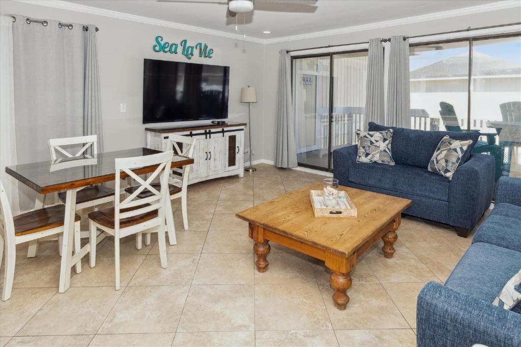 sala de estar con sofá, mesa y TV en Sandpiper Cove 2138 Destin Condo, en Destin