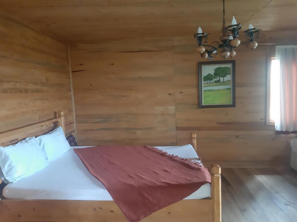 a bedroom with a bed in a log cabin at ida bay doğa evleri in Edremit