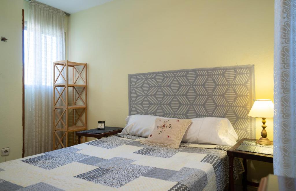 ein Schlafzimmer mit einem Bett mit einer blau-weißen Decke in der Unterkunft Habitación doble con baño compartido en Benalmadena in Benalmádena