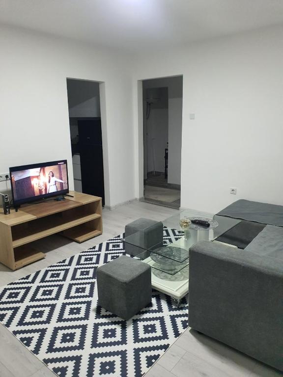 Una sala de estar con un televisor de pantalla plana y un sofá. en Ajša apartmani, en Sarajevo