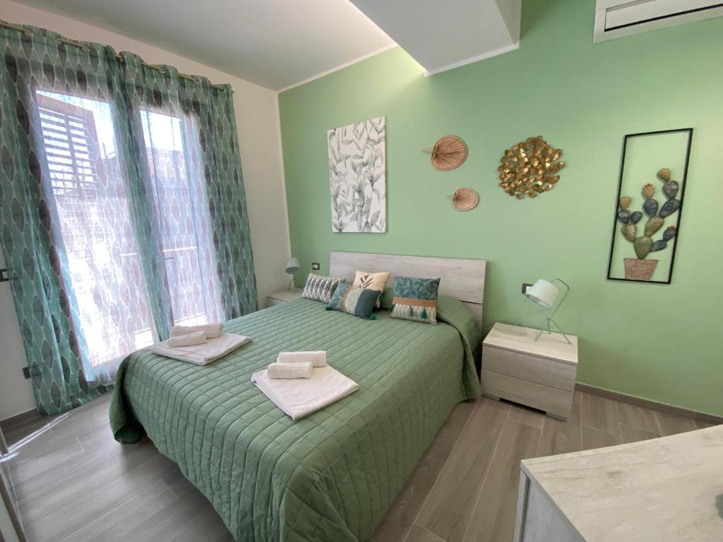 Un dormitorio con una cama verde y una ventana en La Terrazza del Capo en San Vito lo Capo