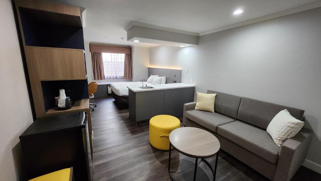 ein kleines Wohnzimmer mit einem Sofa und einem Bett in der Unterkunft Quality Inn & Suites in Santa Rosa