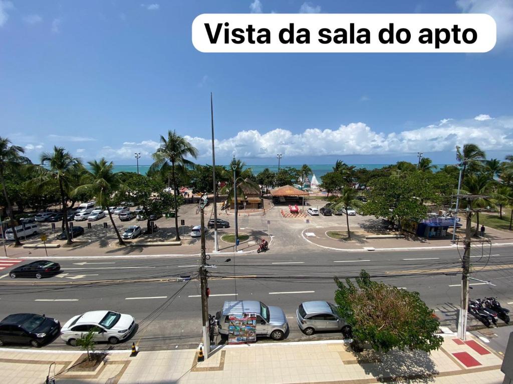 a street with cars parked in a parking lot at Beira-mar na praia pajuçara Dois quartos - Apto 302 in Maceió