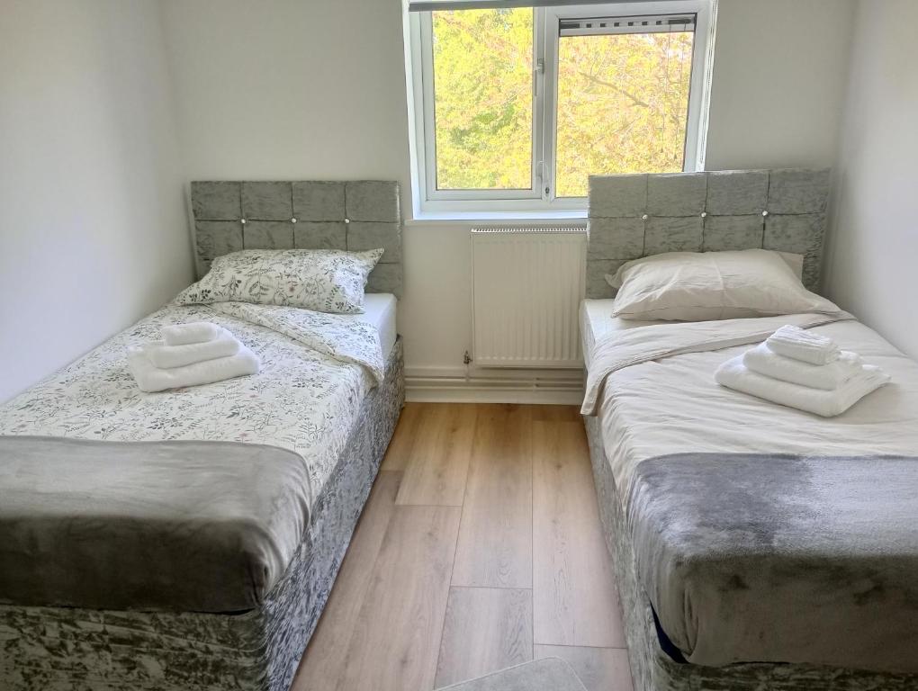 2 Einzelbetten in einem Zimmer mit 2 Fenstern in der Unterkunft Deep sleep Bedroom in Oxford