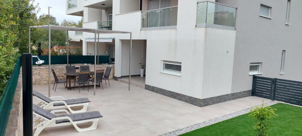 un patio avec des chaises et une table dans un bâtiment dans l'établissement Apartment Luna Banjole, à Banjole