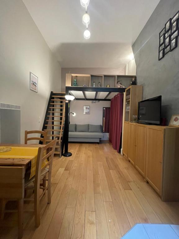 - un salon avec une table à manger et un escalier dans l'établissement 巴黎圣母院单间公寓, à Paris