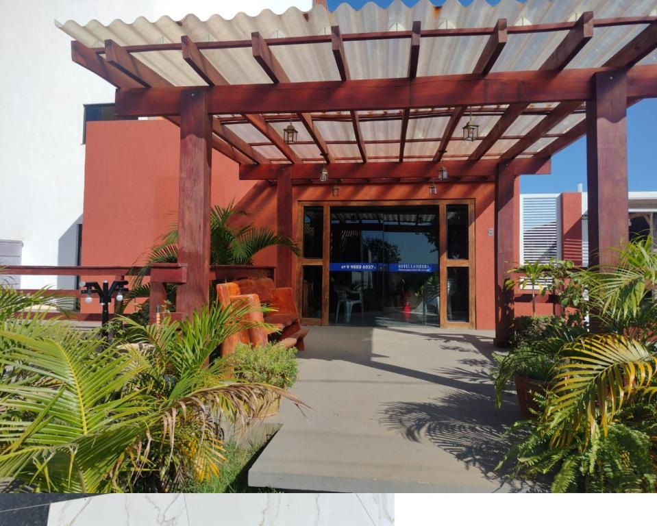 a wooden pergola in front of a building at HOTEL LA SIERRA in Bodoquena