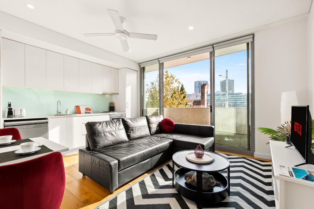 a living room with a couch and a table at Central, modern 1 bedroom with air-con & balcony in Sydney