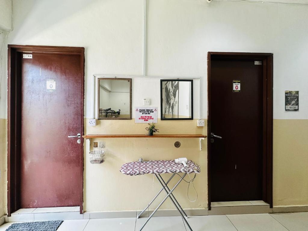 una habitación con dos puertas y un taburete en la parte delantera en H2 Segama Backpacker en Kota Kinabalu