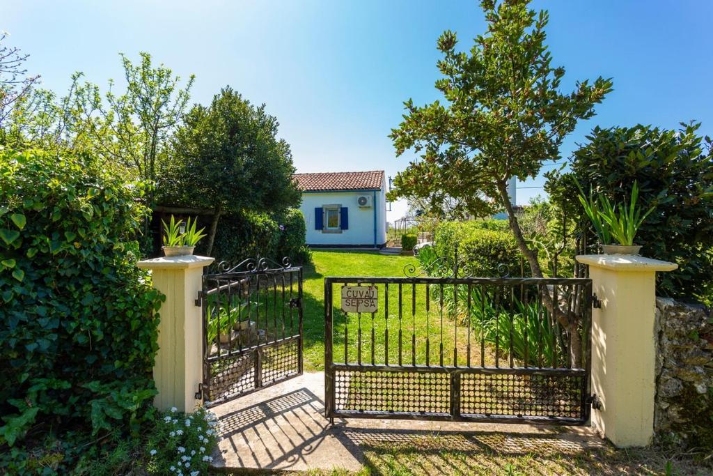 un cancello per un giardino con una casa sullo sfondo di Holiday house with a swimming pool Vinez, Labin - 22240 a Vinež