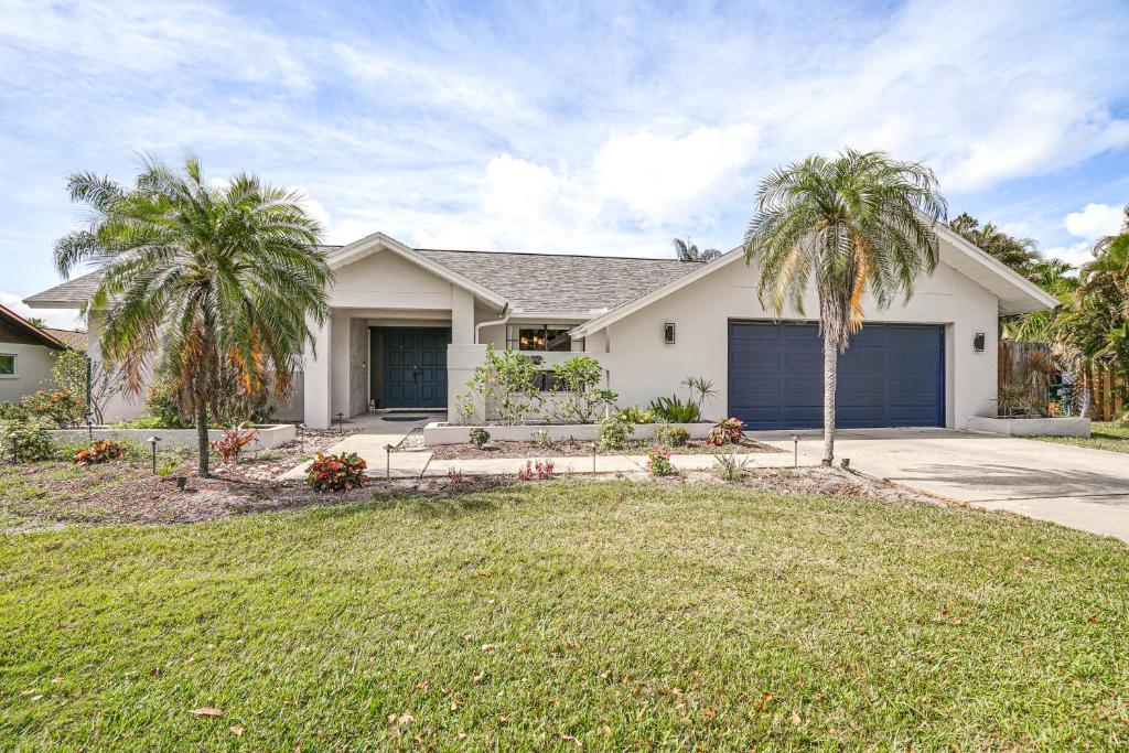 a house with two palm trees in a yard at Fort Myers Home, Lanai and Private, Heated Pool in Fort Myers