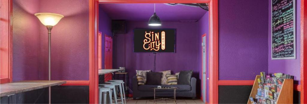 Cette chambre violette comprend un canapé et une table. dans l'établissement Sin City Hostel, à Las Vegas