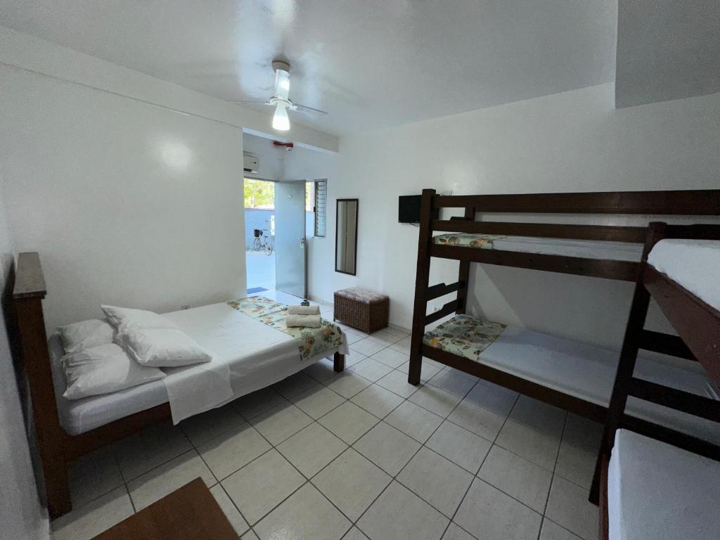 a bedroom with two bunk beds and a window at Pousada Suíte Verde Mar in Ubatuba