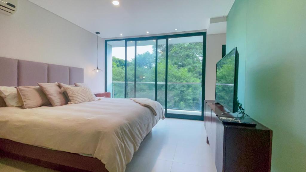 a bedroom with a bed and a large window at Luxurious stay at modern apartment (Equipetrol) in Santa Cruz de la Sierra