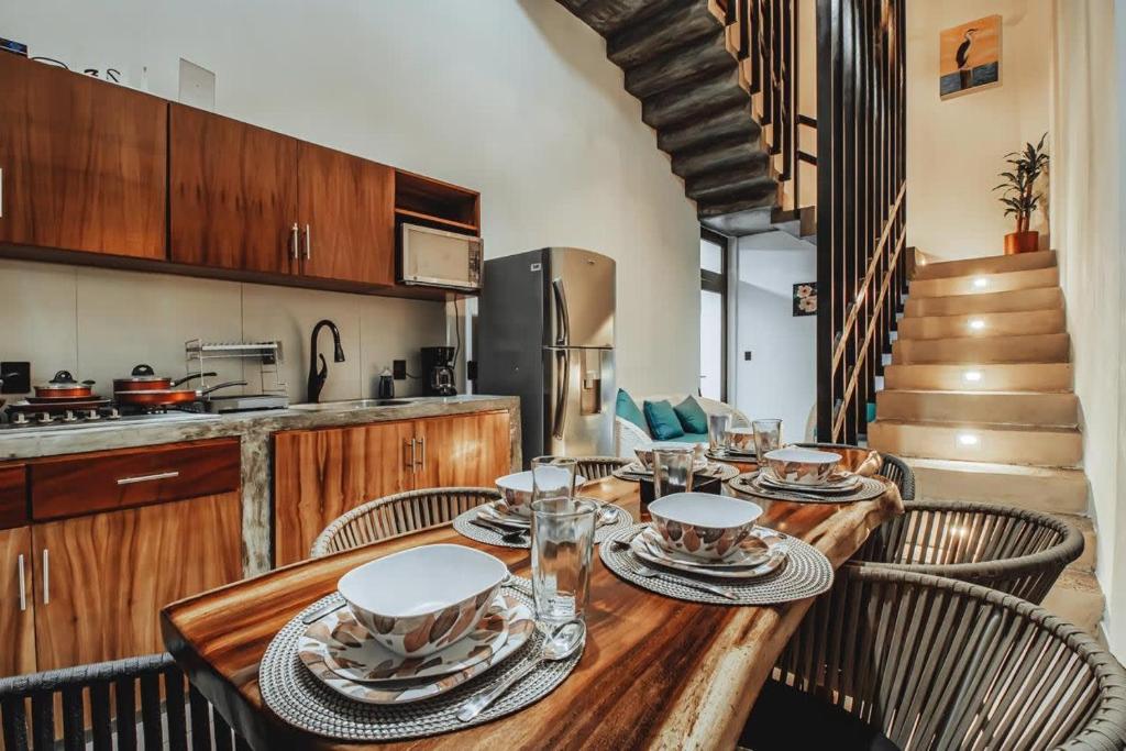 uma sala de jantar com uma mesa de madeira e cadeiras em New La Manzanilla Paradise Vibrant Pool Home em La Manzanilla