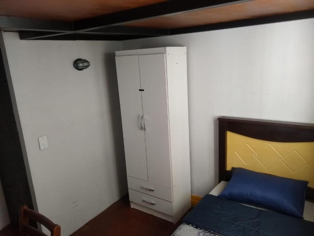 a bedroom with a bed and a white cabinet at Gran Village Hostel in Sao Paulo