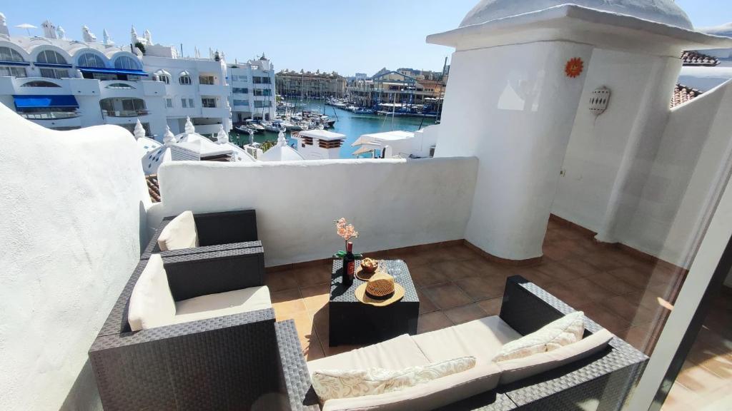 - un balcon avec des canapés, une table et un port dans l'établissement Puerto Marina luxury apartment with sea views, à Benalmádena