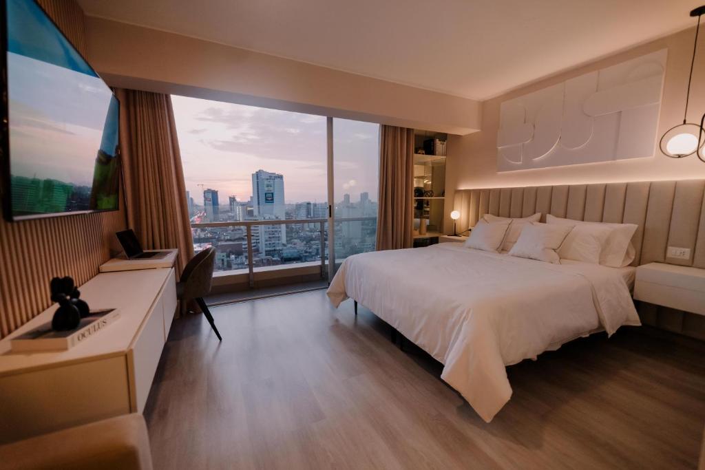 a hotel room with a bed and a large window at Loft Javier Prado in Lima