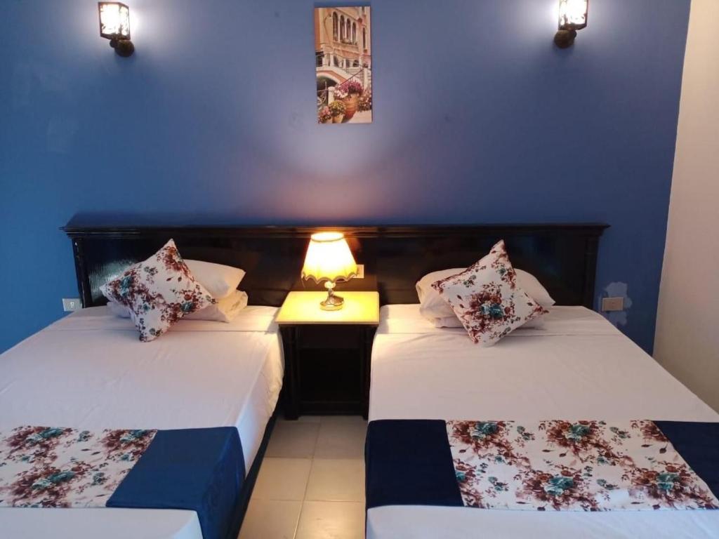 two beds in a room with blue walls at Regency Hotel in Sharm El Sheikh