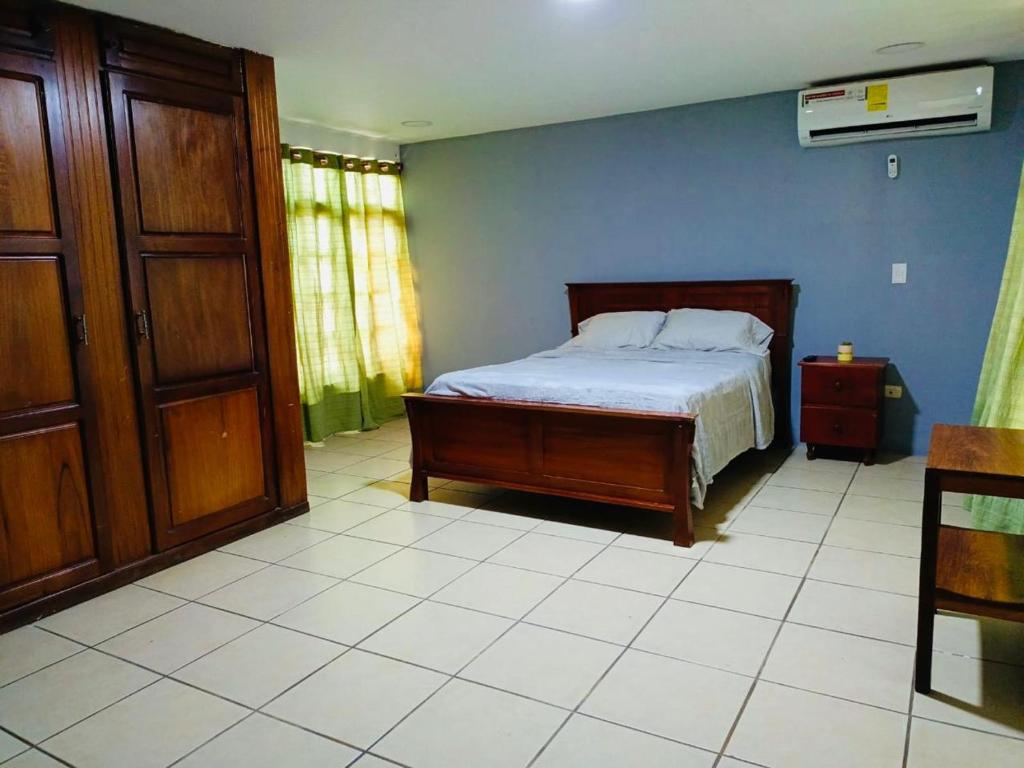 a bedroom with a bed and a wooden door at Linda Vista Hostal in Managua