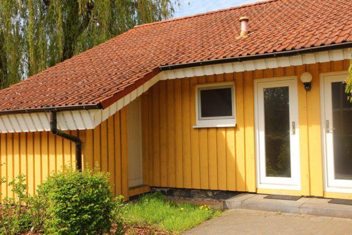 una pequeña casa amarilla con techo rojo en Möwe 35, en Mirow