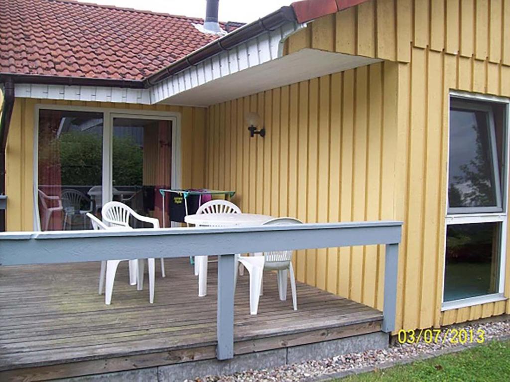 eine Terrasse mit Stühlen und einem Tisch auf einem Haus in der Unterkunft Möwe 104 in Mirow
