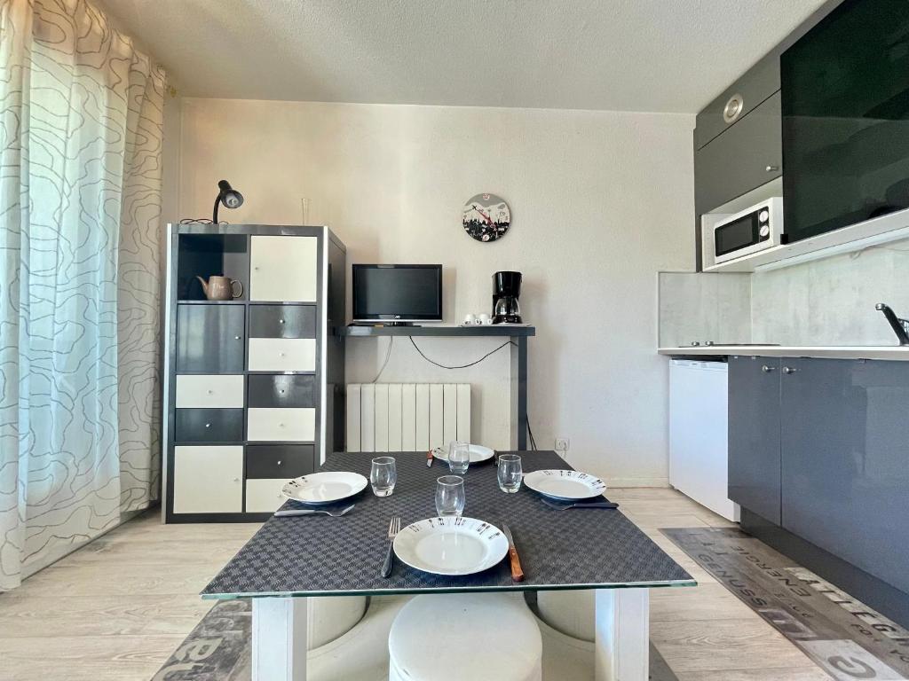 une salle à manger avec une table et une cuisine dans l'établissement Joli studio-cabine moderne à 300m de la plage - FR-1-338-368, à Sète