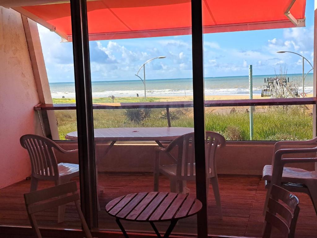 une table et des chaises avec vue sur la plage dans l'établissement Appartement Confortable avec Balcon - Saint Jean de Monts - FR-1-323-532, à Saint-Jean-de-Monts