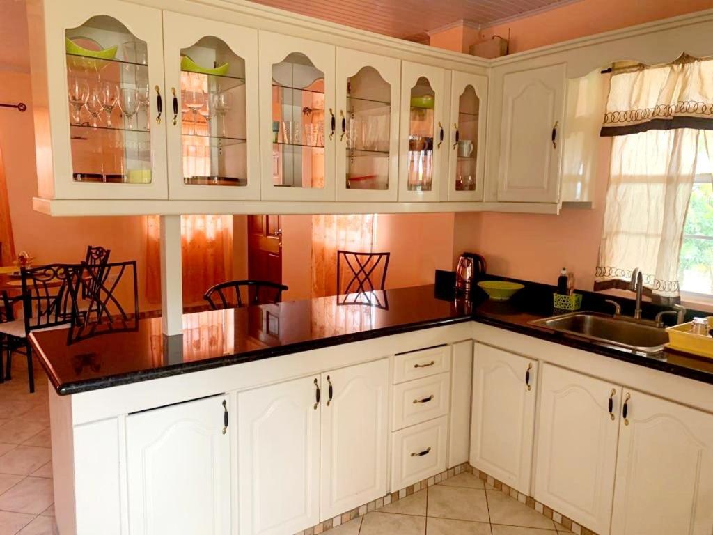 a kitchen with white cabinets and a sink at Anne Marie Villas in Castries