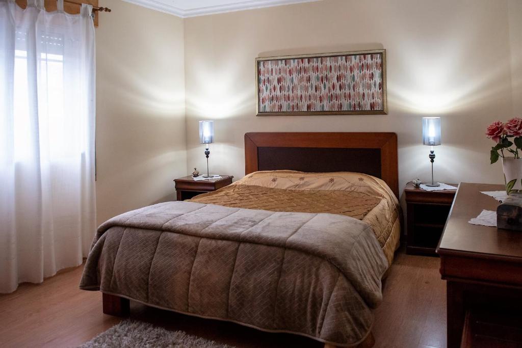 アングラ・ド・エロイーズモにあるCasa Espaçosa perto de Angraのベッドルーム1室(ベッド1台、ナイトスタンド2台、ランプ2つ付)