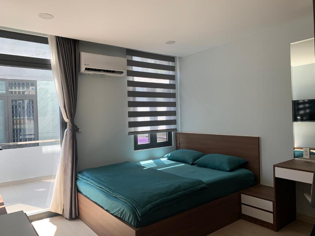 ein Schlafzimmer mit einem grünen Bett und einem Fenster in der Unterkunft LUCY HOTEL & APARTMENT D1 in Ho-Chi-Minh-Stadt