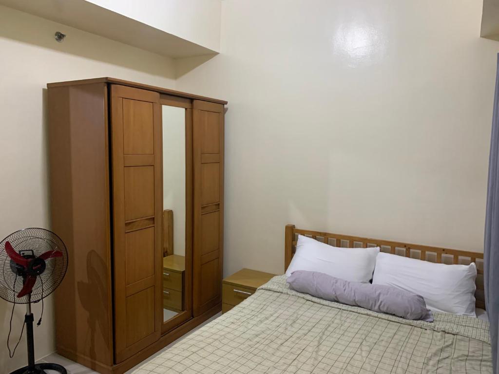 ein Schlafzimmer mit einem Bett, einem Schrank und einem Ventilator in der Unterkunft 2BR unit @ CHATEAU ELYSEE vendome tower 6th flr in Manila