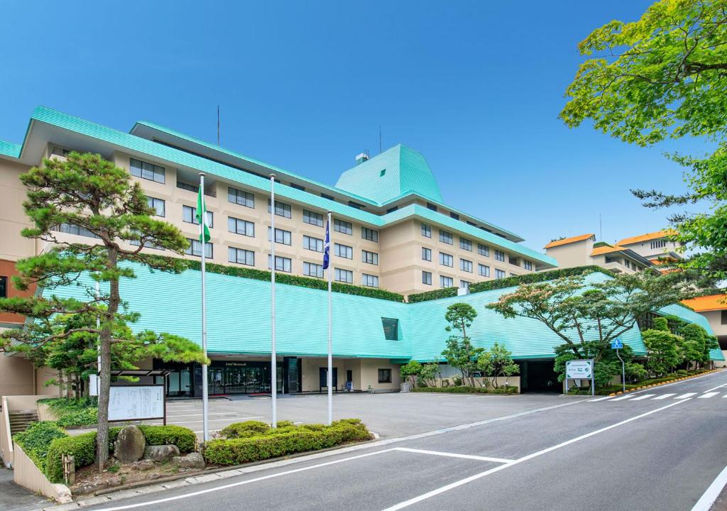 Hotel Hanamaki في هاناماكي: مبنى كبير بالواجهة الزرقاء على شارع