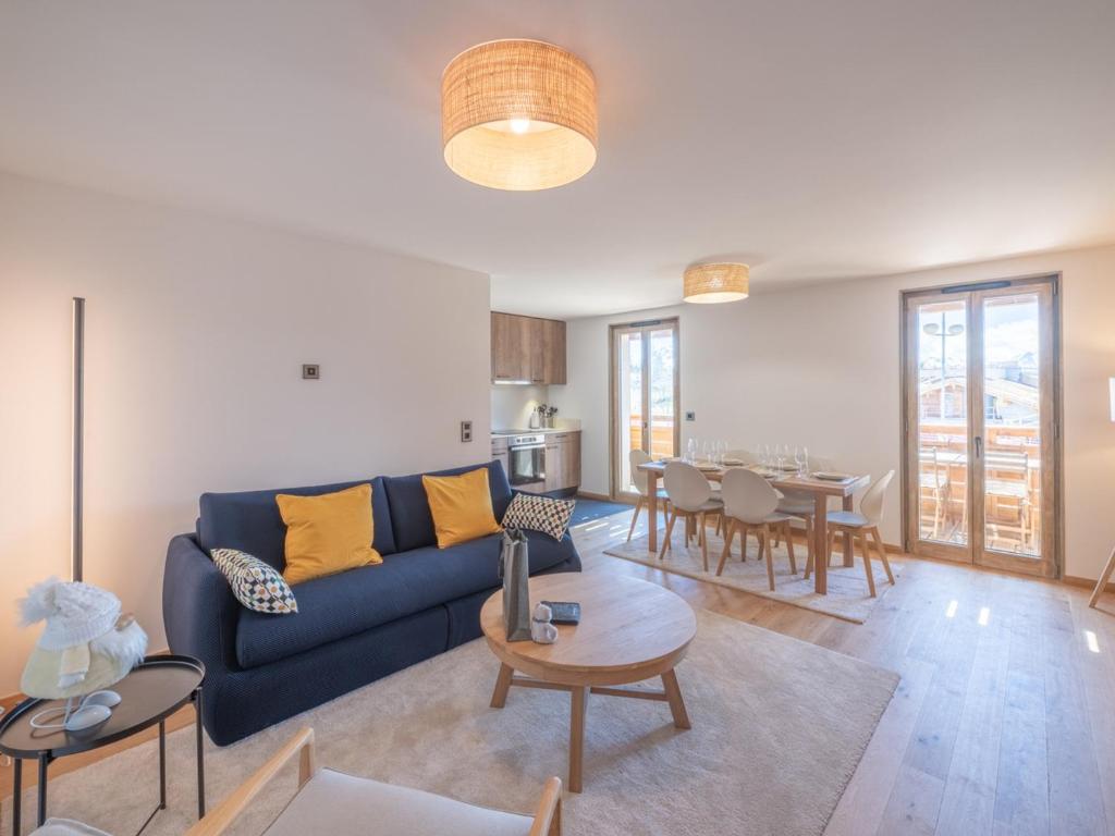 uma sala de estar com um sofá azul e uma mesa em Appartement Huez, 3 pièces, 4 personnes - FR-1-645-72 em LʼHuez